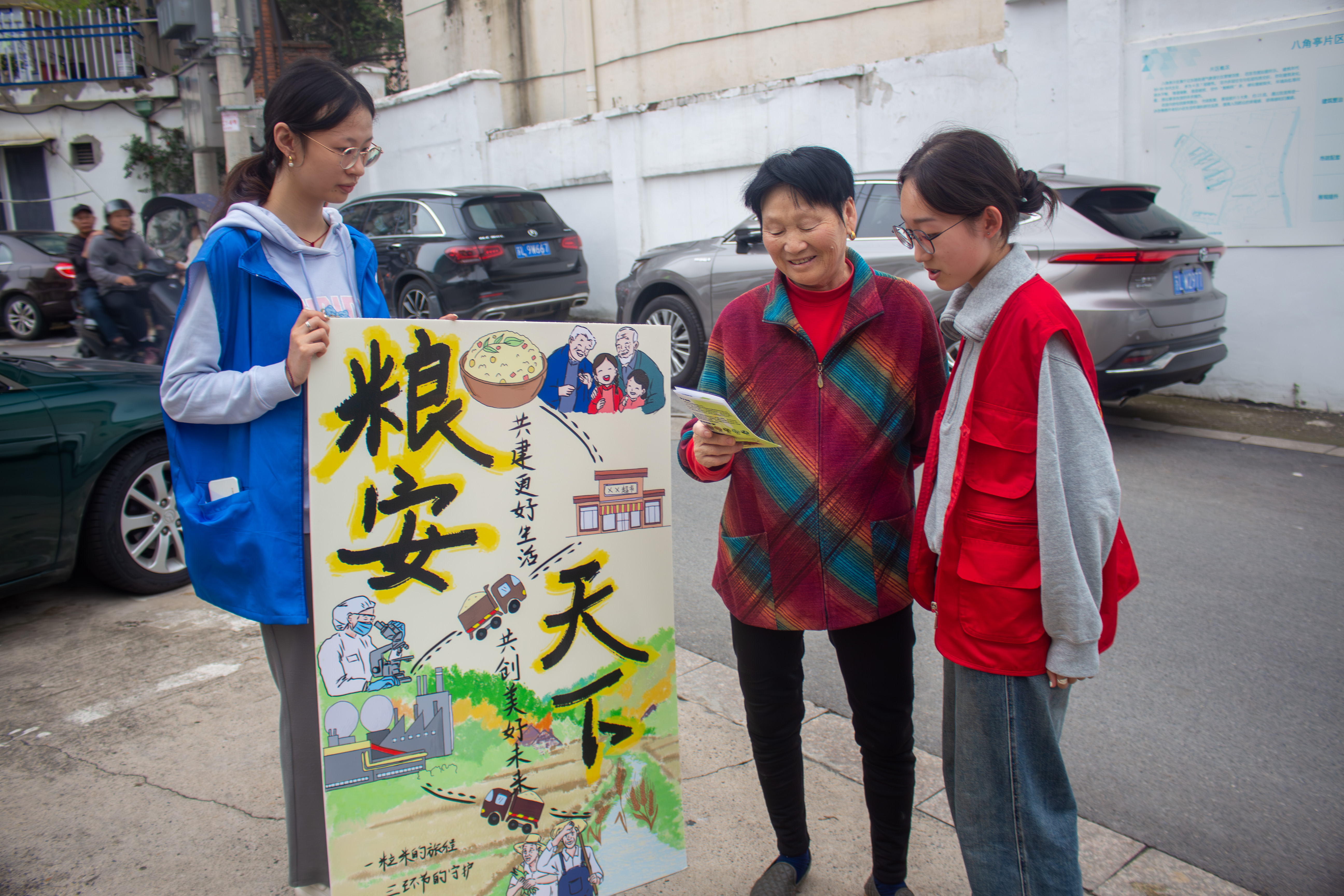 1729088238727024.jpg 图为志愿者向社区居民宣传节粮减损海报优秀作品.JPG