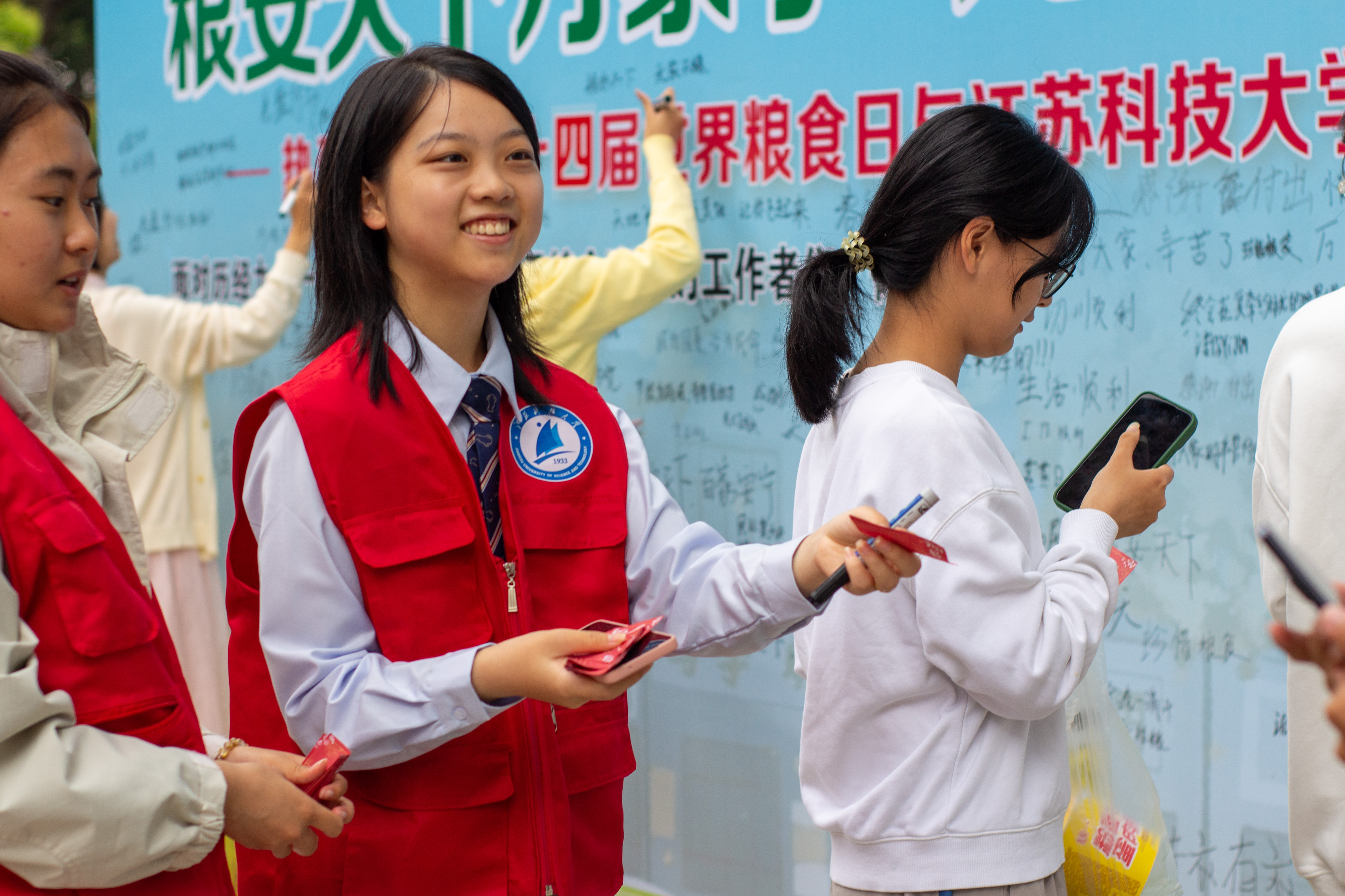 1729088526455589.jpg 图为志愿者在活动现场引导同学参与节粮竞答.JPG