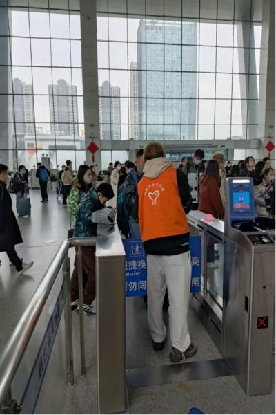 1679895716414232.jpg 图为志愿服务小队成员许丁嵩维持现场秩序,解决旅客问题 申英杞 摄.jpg