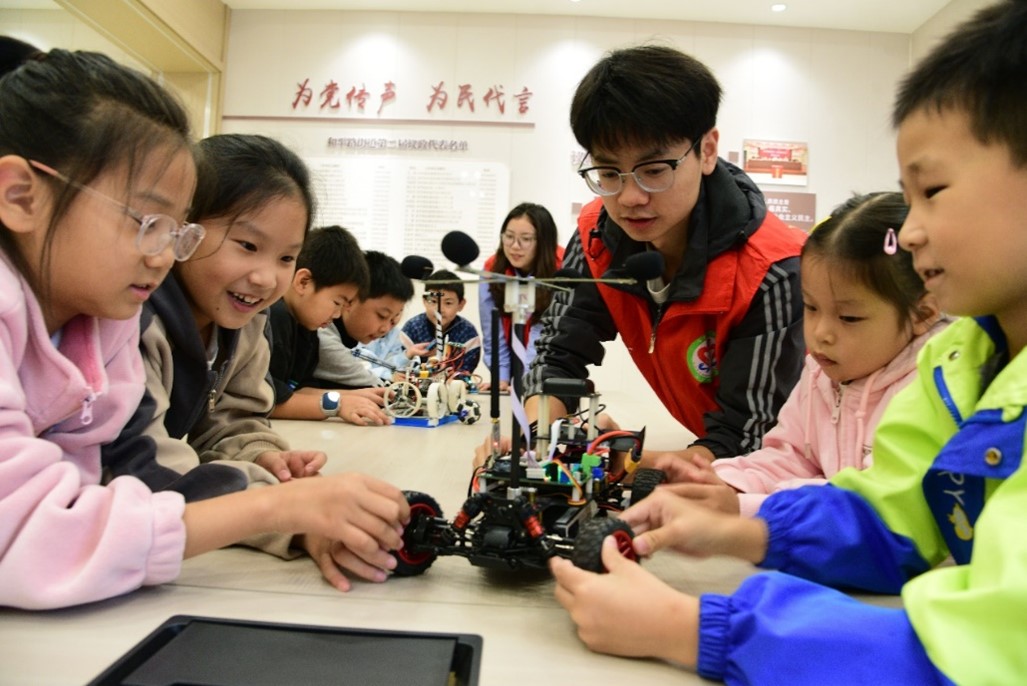 1729488635111145.jpg 图4 志愿者为小朋友讲解智能小车.jpg